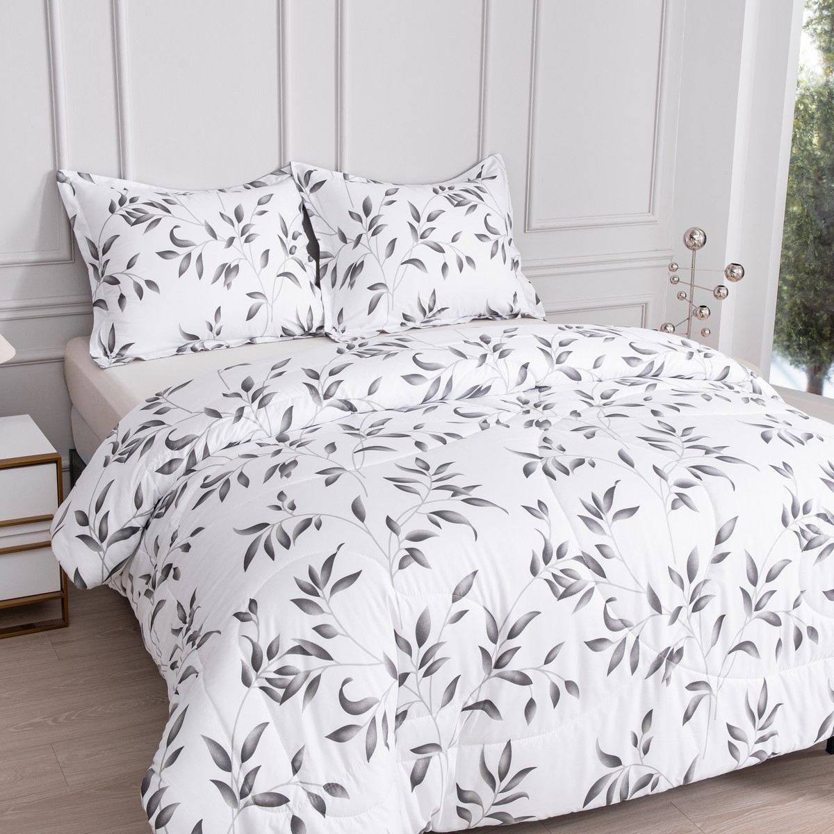 Opgemaakt bed met tweedelig ritsbaar dekbed Nora in wit met grijze bladeren en bijpassende kussens.
