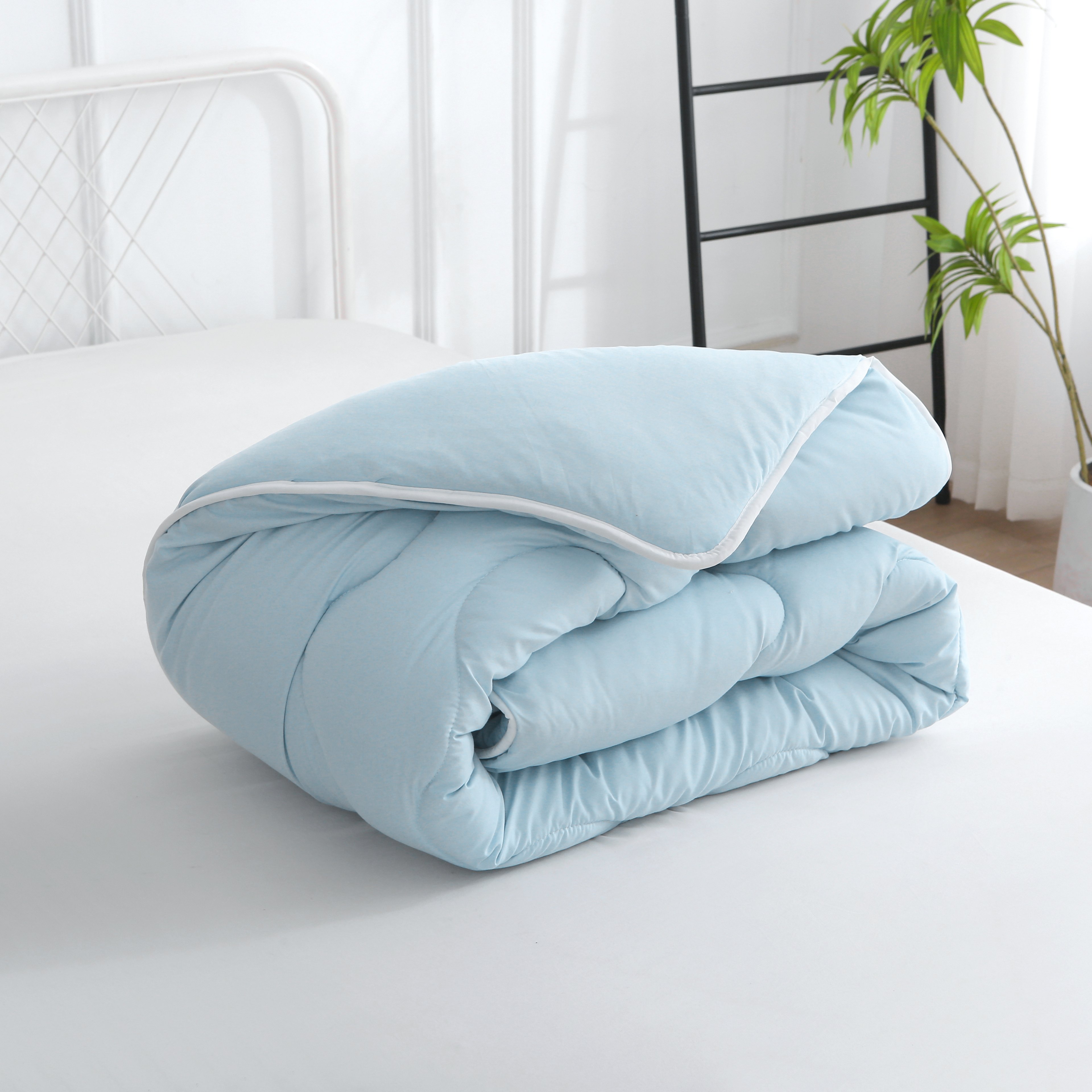 Opgevouwen blauw hoesloos dekbed met verkoelend effect en vaste hoes, licht en ademend